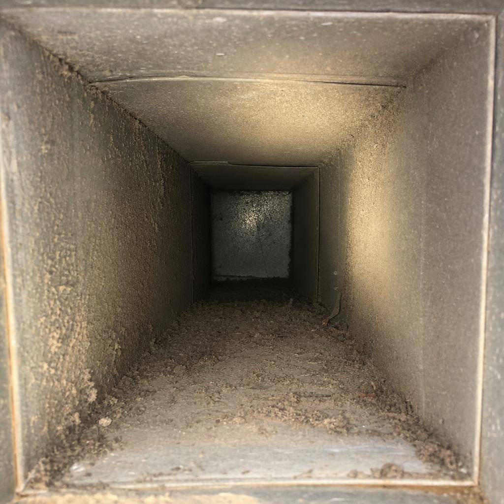 Inside view of a residential air duct before cleaning